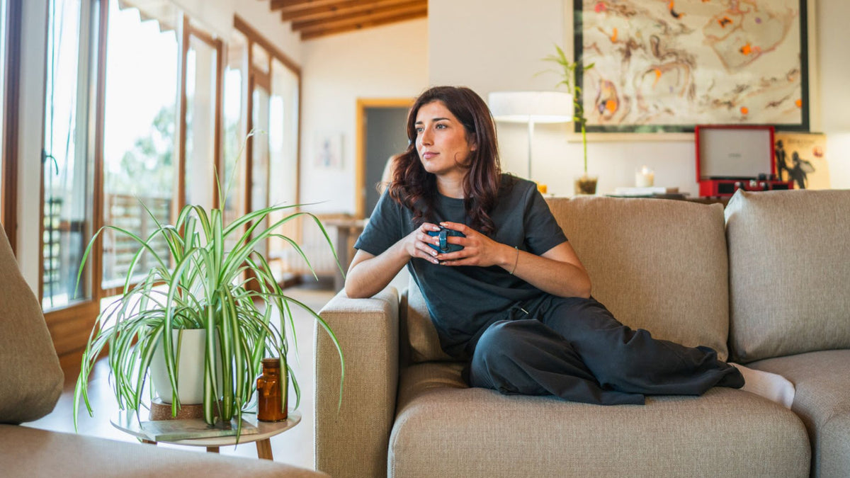 Femme se reposant sur un canapé La Siesta près d’une fenêtre