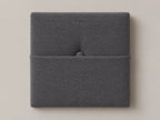Cabecero modular tela tejida gris, capitoné con bolsillo a media altura y botón tapizado central. Módulo de 30 × 30 × 3,5 cm.