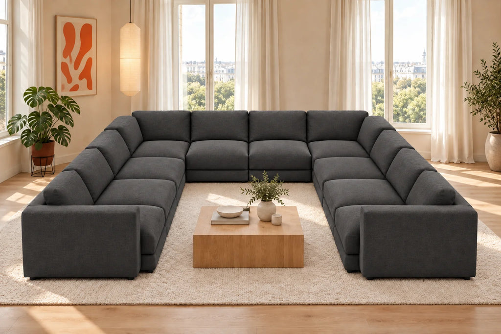 Sofá modular rinconero en U, composición U-3-2-3, tapizado en tela entrelazada gris, en un salón luminoso con madera clara y tonos naturales.