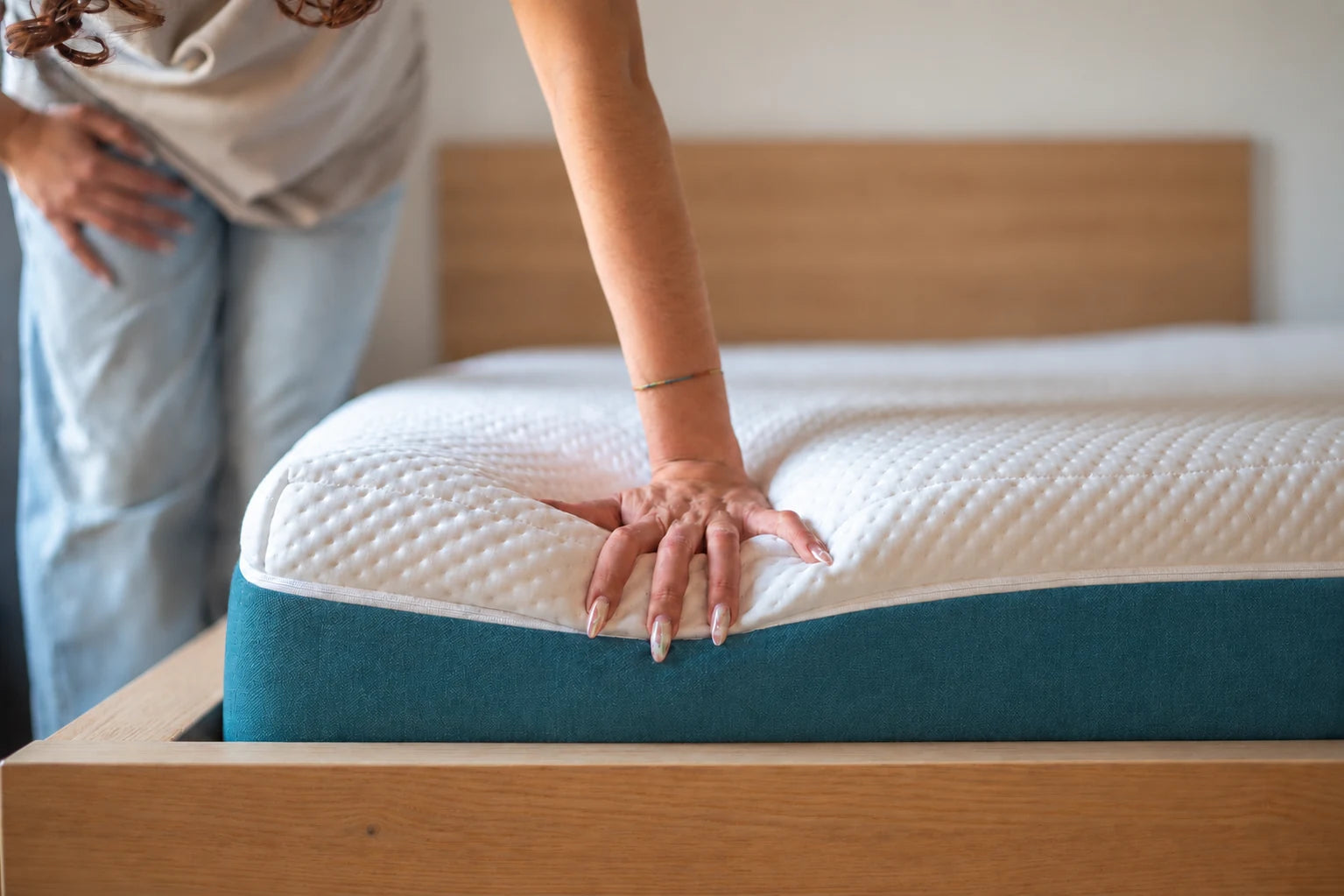 Detalle del colchón La Siesta con franja corporativa lisa sobre un somier de madera
